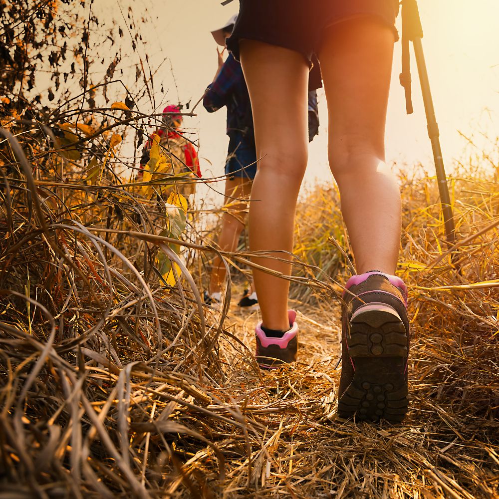 Hiking through the countryside at sunset with outdoor shoes.