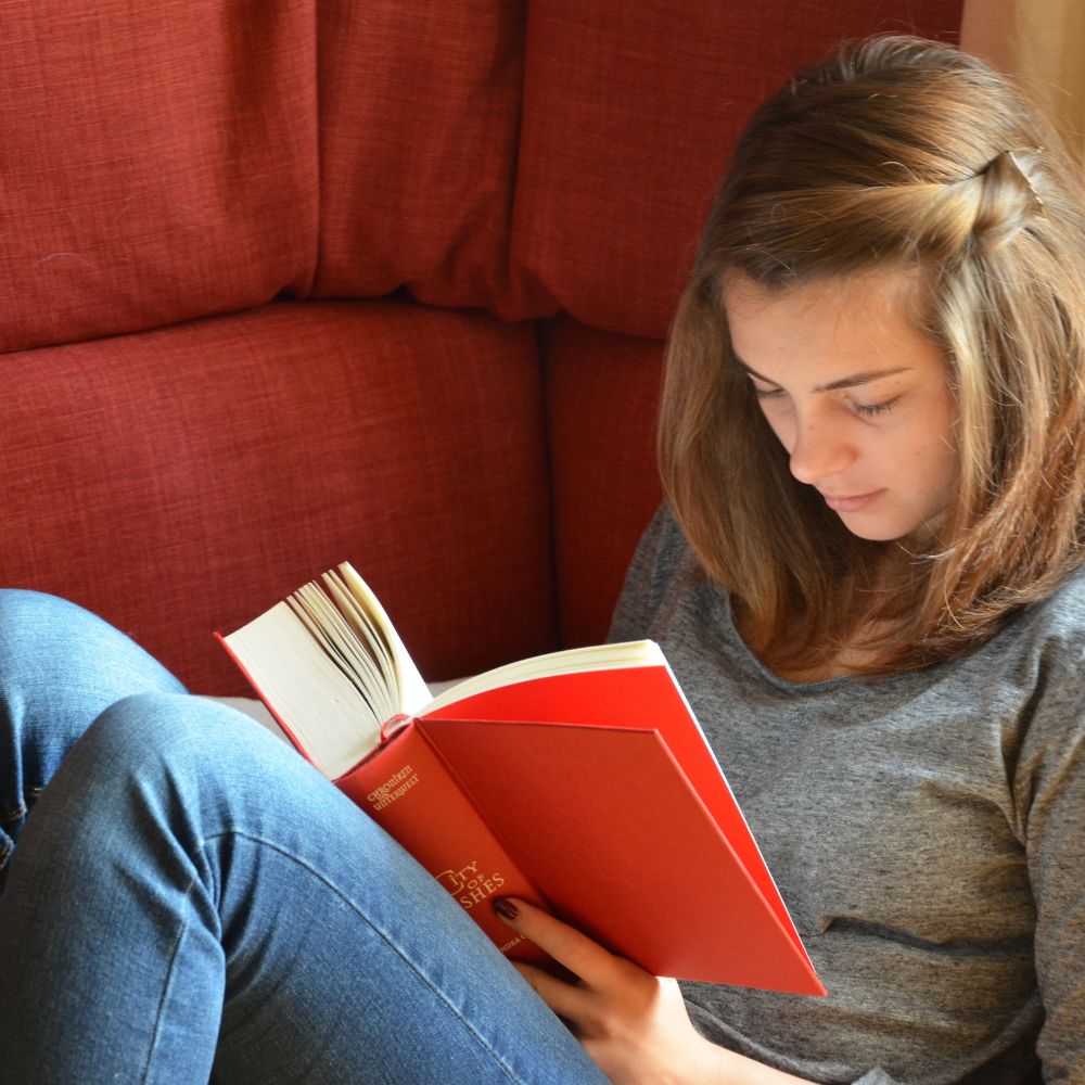 Reading a book and relaxing on a cozy couch.