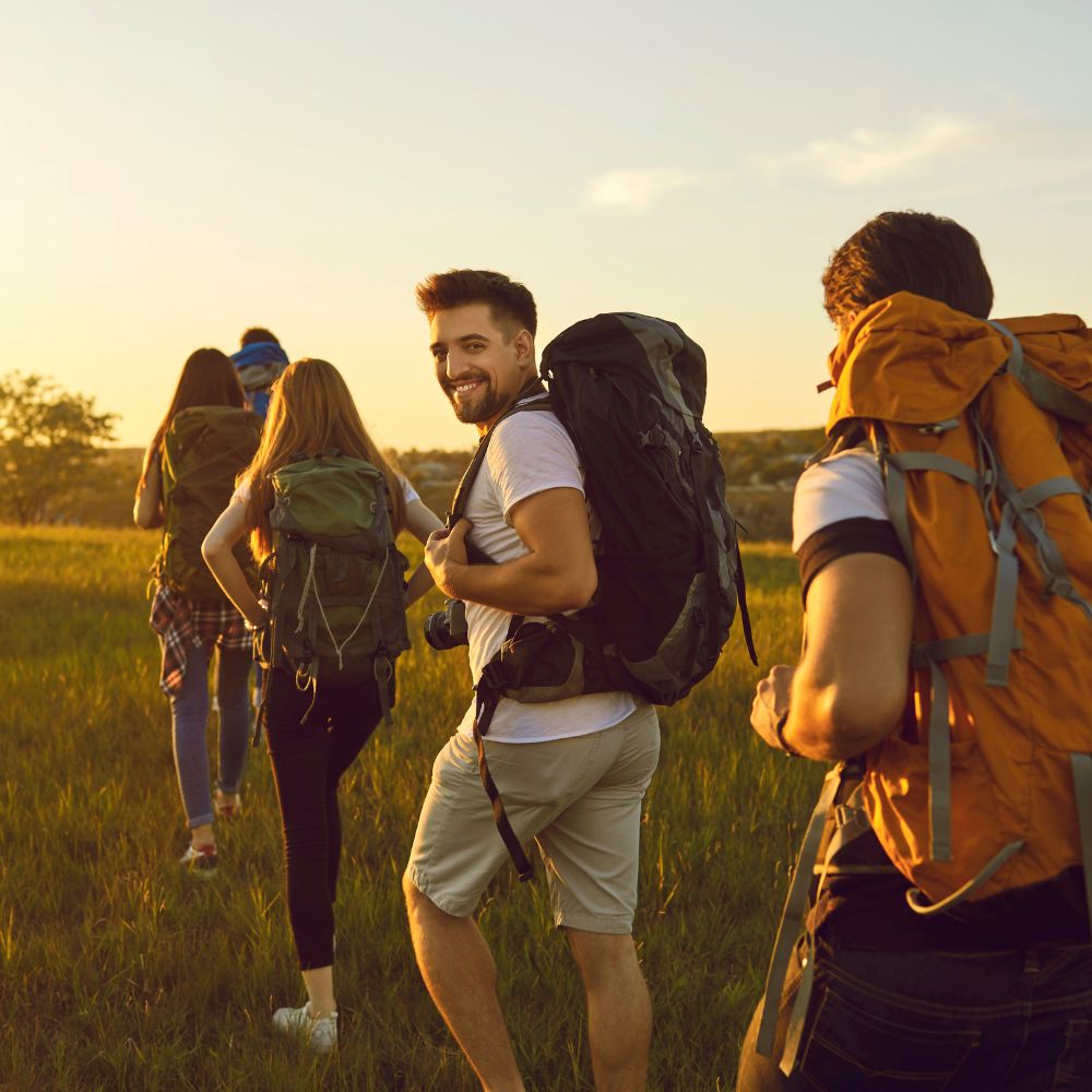 Group of hikers enjoying a scenic view during sunset.