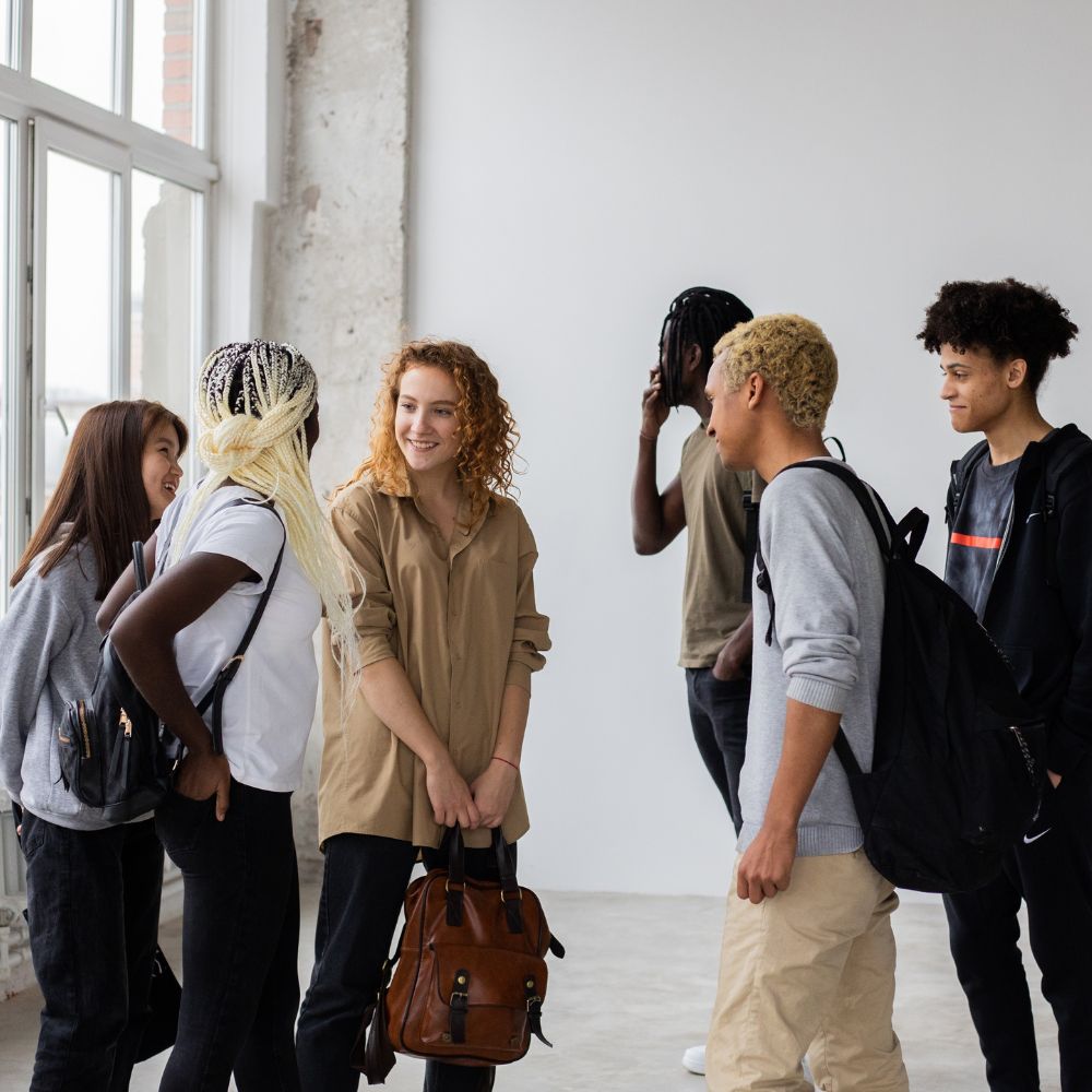Group of college students chatting in bright hallway