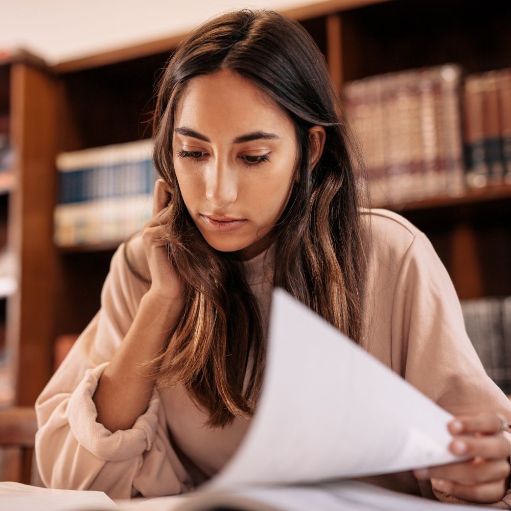 Student studying alone in library with serious focus